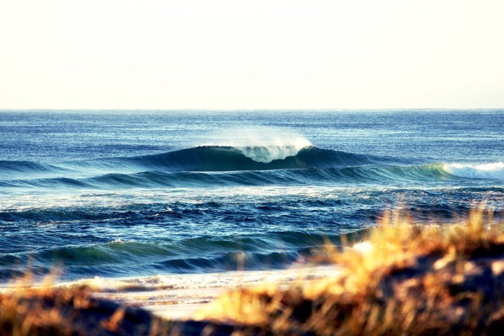 a man riding a wave on a surfboard in the ocean