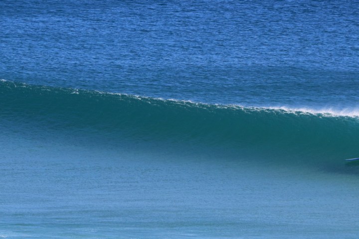 a man riding a wave on a surfboard in the water