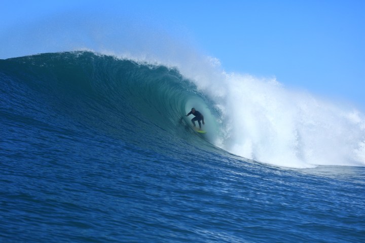 a man riding a wave on a surfboard in the water