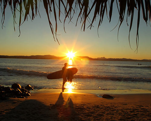 a sunset over a sandy beach next to the ocean