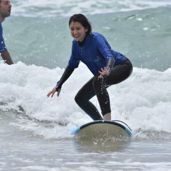 a young girl riding a wave on a surfboard in the ocean