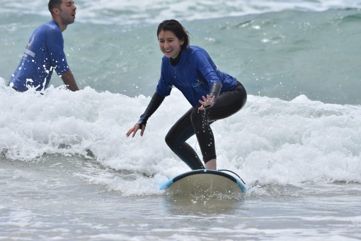 a young girl riding a wave on a surfboard in the ocean