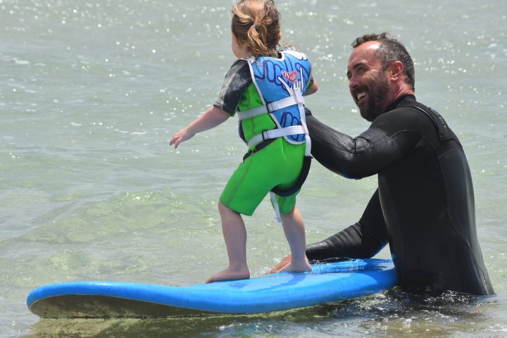 a young girl riding a wave on a surfboard in the ocean