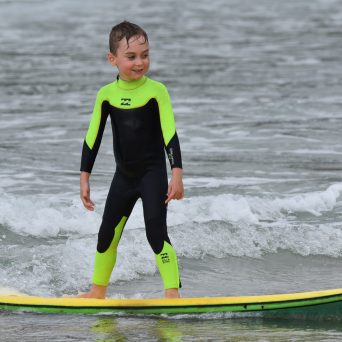 a young boy riding a wave on a surfboard in the ocean