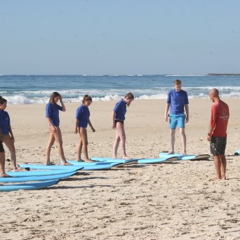 a group of people standing on top of a sandy beach