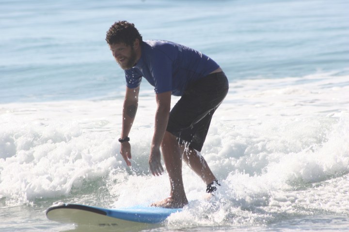 a man riding a wave on a surf board on a body of water