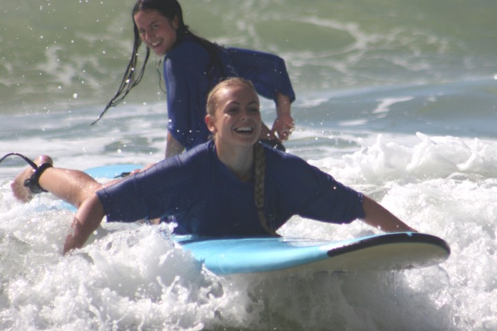 a girl riding a wave on a surfboard in the water