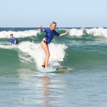 a girl riding a wave on a surfboard in the water
