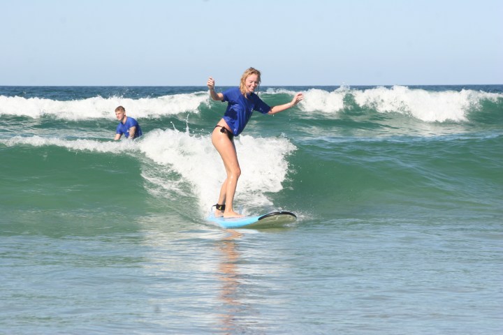 a girl riding a wave on a surfboard in the water