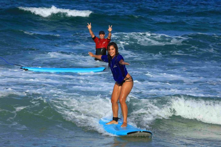 a young girl riding a wave on a surfboard in the ocean