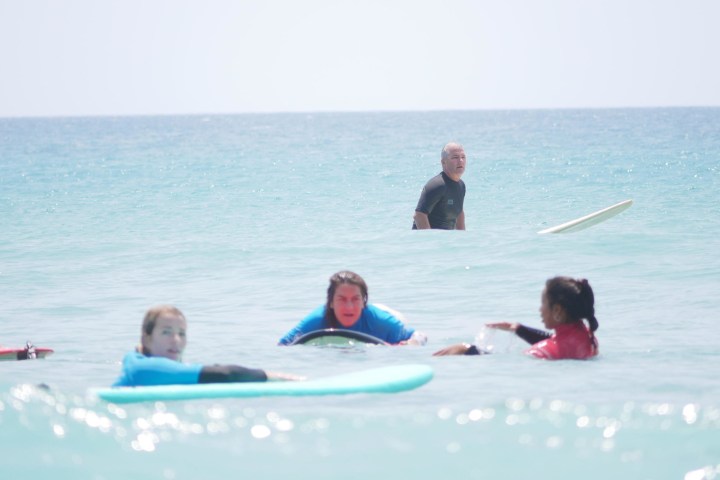 a group of people learning to surf
