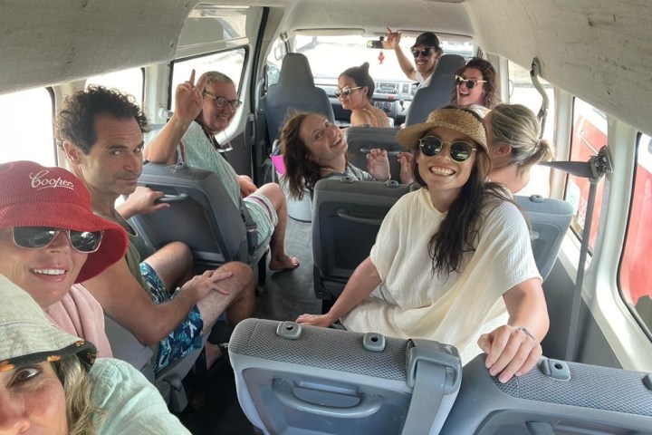 a group of people sitting around a car